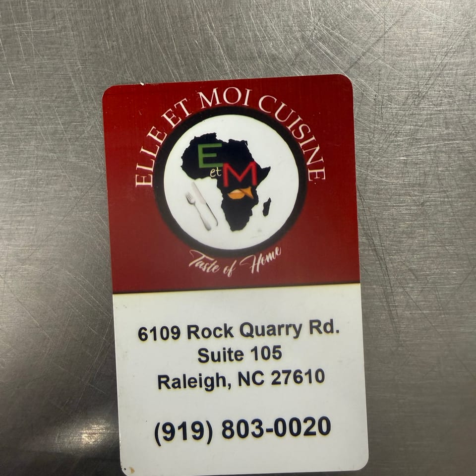 Restaurant sign for Le Filet Moi Cuisine, featuring an Africa map logo, Raleigh address, and phone number on a scratched metal surface.